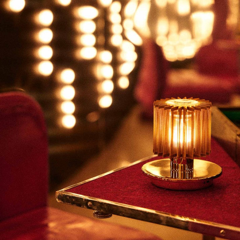 DCW Editions In The Sun Table Lamp with a Gold base and gold mesh shade in a restaurant